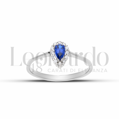 Contornato da una fila di zirconi Modello con Pietra di Colore Blu e zirconi bianchi in Oro Bianco da 1,9gr.