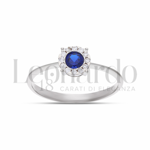 Contornato da una fila di zirconi Modello con Pietra di Colore Blu e zirconi bianchi in Oro Bianco da 1,9gr.